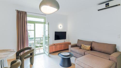 a living room with a couch and a tv at Paleochora Central Apartments in Palaiochóra