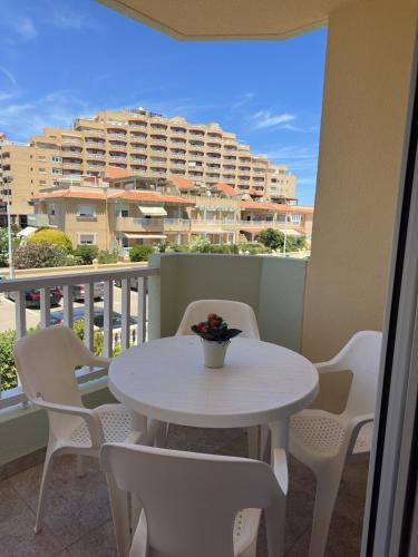 a white table and chairs on a balcony with a building at Ipanema 52 - La Manga By WATERMELON in La Manga del Mar Menor