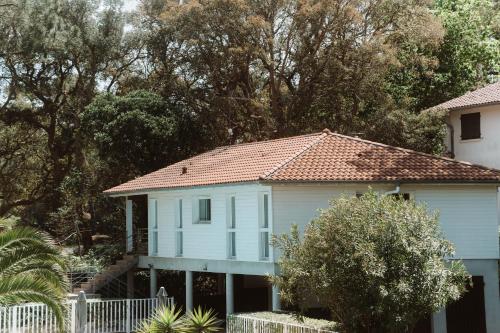 a white house with a red roof at Maison du Parc - Vue canal in Hossegor