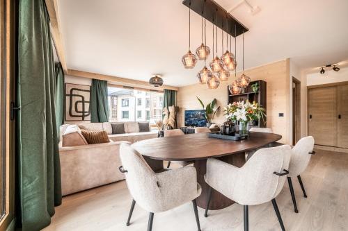 un salon avec une table et des chaises en bois dans l'établissement Apartment Tineo Alpe D'Huez - by EMERALD STAY, à L'Alpe-d'Huez