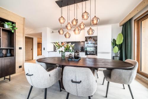 a dining room with a wooden table and chairs at Apartment Tineo Alpe D'Huez - by EMERALD STAY in L'Alpe-d'Huez