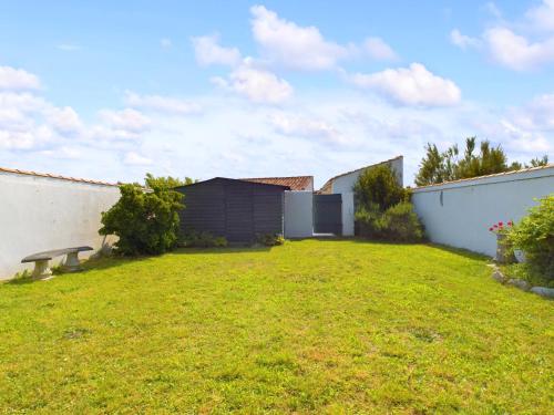 an empty yard with a fence and a lawn at A 180m du bord de mer, maison pour 11 in Saint-Clément-des-Baleines