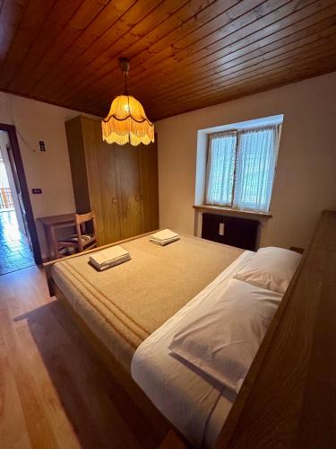 a bedroom with a large bed with a chandelier at Casa Defrancesco in Panchià