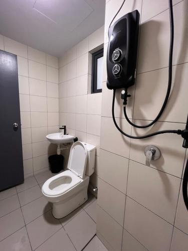 a bathroom with a toilet and a phone on the wall at AS Homestay Gamuda Gardens Gaia Residence 2R1B Rawang Skyline Luge in Rawang