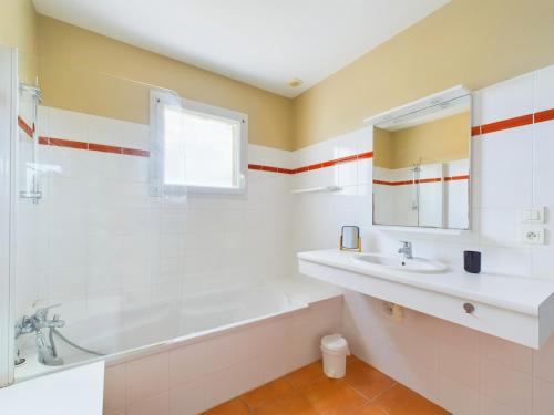 une salle de bain avec une baignoire et un lavabo dans l'établissement Maison pour 7, piscine collective, 2km de la plage, à Les Sables-dʼOlonne