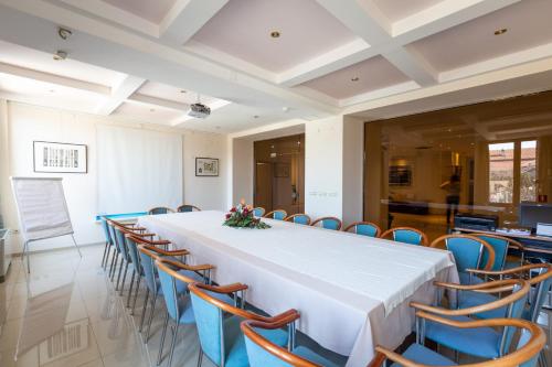 a long table and chairs in a room with a white table at Apollonia Hotel Gevgelija in Gevgelija