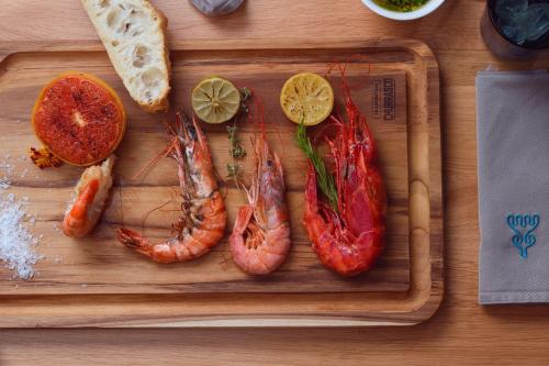 a cutting board with lobes of shrimp and slices of bread at Hotel Blü Gastein in Bad Hofgastein