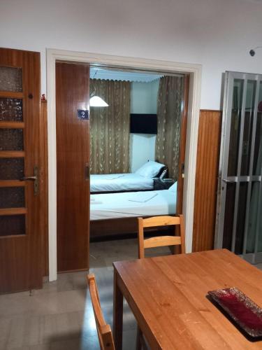 a bedroom with a bed and a table and a mirror at FLAT with Private Rooms in Agrinion