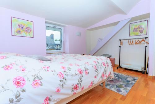 Un dormitorio con una cama con una colcha floral. en LE NID DES MOUETTES, en Cherbourg-en-Cotentin