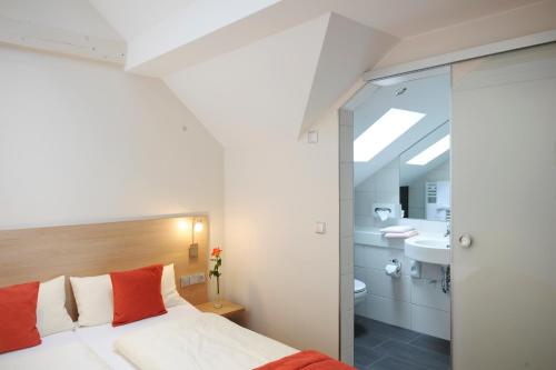 a bedroom with a bed and a bathroom at Weingut und Gästehaus Josef Reis in Mehring