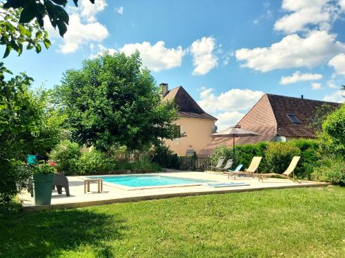 une piscine dans l'arrière-cour d'une maison dans l'établissement Au pays de Jacquou : Chambre d’hôtes et table d’hôtes, à Fossemagne