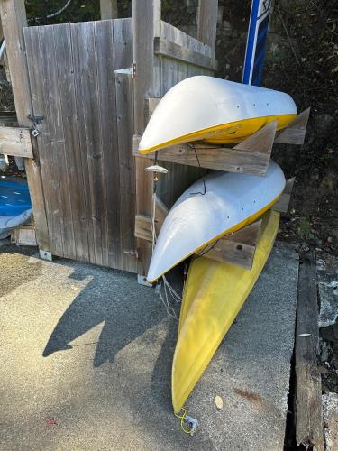 a pair of surfboards sitting on a bench next to a fence at Thetis Island Get Away Cottage in North Galiano
