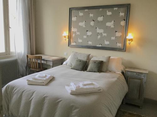 une chambre avec un lit avec deux serviettes dessus dans l'établissement Le Logis Alexandra BnB, à La Trimouille