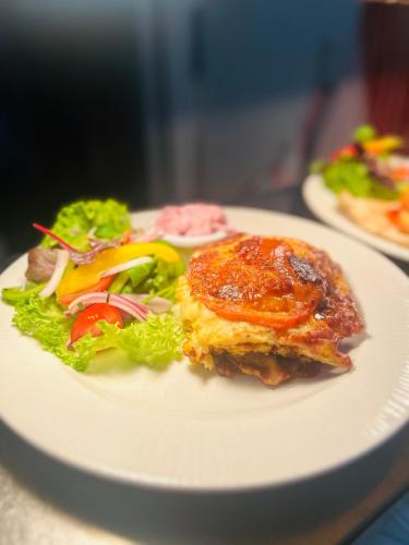 a white plate with a sandwich and salad on it at Angel Inn Misson in Misson