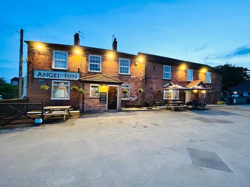 an empty parking lot in front of a brick inn at Angel Inn Misson in Misson