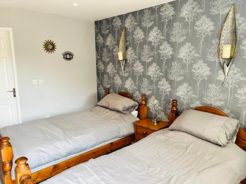 two twin beds in a room with a wallpaper at Angel Inn Misson in Misson