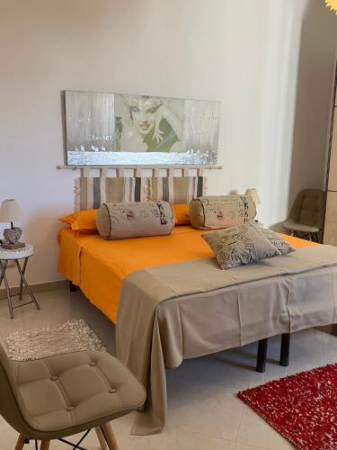 a bedroom with an orange bed with a picture on the wall at Panorama sui trulli in Alberobello