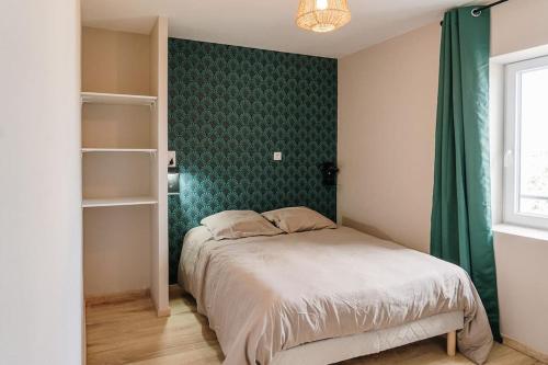 une chambre avec un lit et un mur végétal dans l'établissement Gîte Familial au cœur des vignes, à Béziers