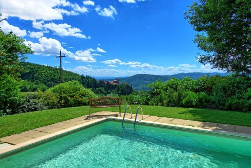 a swimming pool with a bench next to a hill at Poggiolino by PosarelliVillas in Chitignano