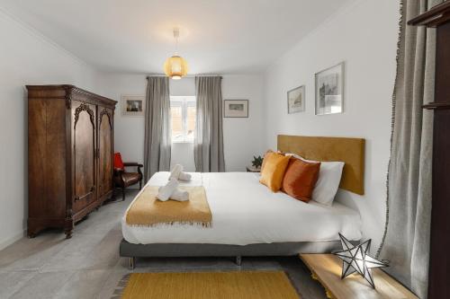 una camera da letto con un letto grande con cuscini arancioni di Casa do Alecrim a Óbidos