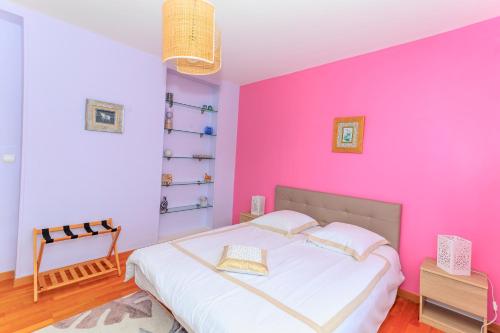- une chambre rose avec un lit et une chaise dans l'établissement UN AIR D'ASIE, à Cherbourg en Cotentin