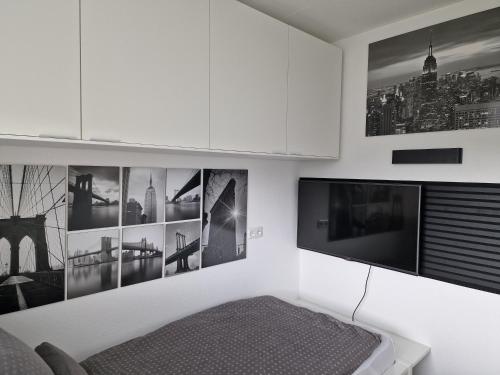 a living room with a tv and pictures on the wall at Ferienwohnungen Fuchs in Duisburg
