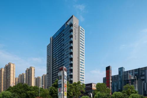 a tall building in the middle of a city at Atour Hotel Changsha Binjiang Financial Center in Changsha