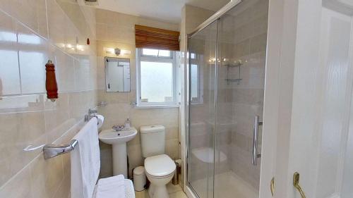 a bathroom with a shower and a toilet and a sink at F40 Bayford, Riviere Towans in Hayle