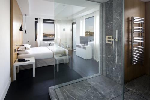 une chambre avec un lit et une salle de bain avec douche dans l'établissement Hôtel Le Versailles, à Villefranche-sur-Mer