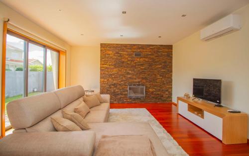 a living room with a couch and a fireplace at Casa do Douro& Porto in Lousada