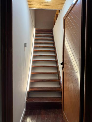 a staircase leading up to a room with a wooden door at Mone luxury villa in Vlorë