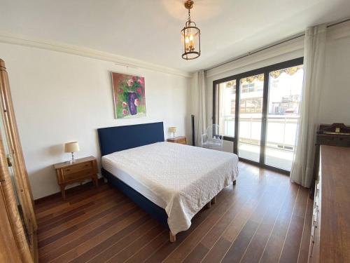 une chambre avec un lit et une grande fenêtre dans l'établissement Cannes proche Croisette - Appartement 3 Pièces vue mer terrasse Helv7, à Cannes