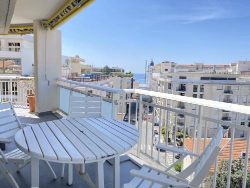 une table et des chaises sur un balcon avec vue sur l'océan dans l'établissement Cannes proche Croisette - Appartement 3 Pièces vue mer terrasse Helv7, à Cannes