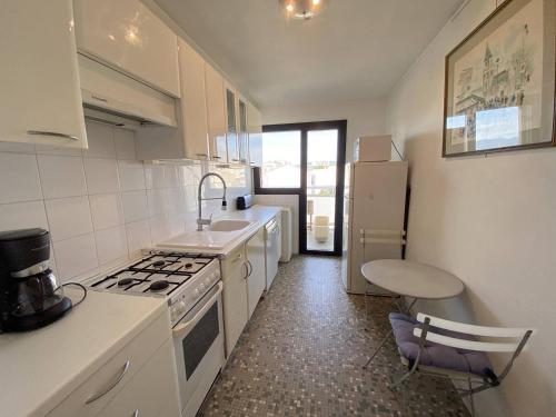 une cuisine avec un évier et une cuisinière four supérieur dans l'établissement Cannes proche Croisette - Appartement 3 Pièces vue mer terrasse Helv7, à Cannes