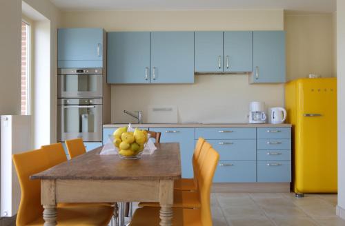 a kitchen with a table with a bowl of fruit on it at Back2Front in Boezinge