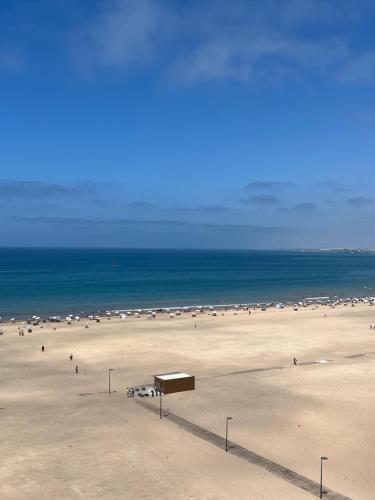 a group of people on a beach with the ocean at Duplex moderne à 1 minute à pied de la plage- Résidence Miramar Mohammedia in Mohammedia