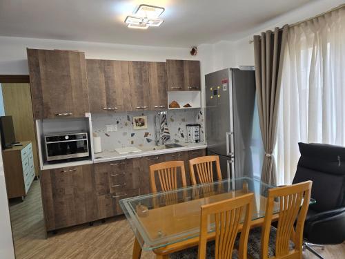 a kitchen with a glass table and wooden cabinets at Апартамент Морската Къща-НЕСТИНАРКА in Tsarevo