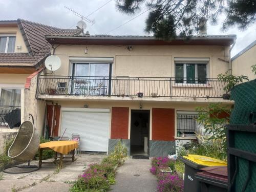 a house with a balcony and a patio at Villa Jasmin in Bobigny