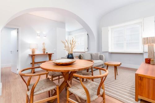 a kitchen and living room with a wooden table and chairs at Limehome Evora Rua de Machede 61 in Évora