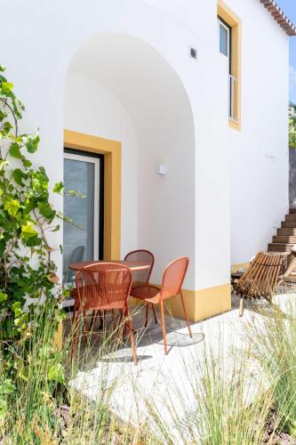 a patio with two chairs and a table and chairs at Limehome Evora Rua de Machede 61 in Évora