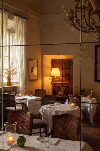 a restaurant with tables and chairs and a mirror at Hotel Certosa Di Maggiano in Siena