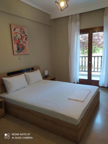 una camera da letto con un letto grande e un balcone di Aura Estiva a Agia Triada