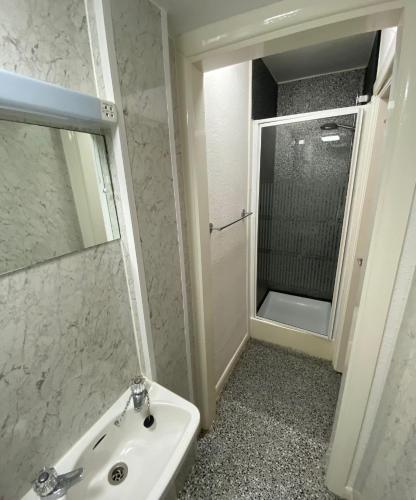 a white bathroom with a sink and a mirror at Farina Holiday apartments in Bridlington