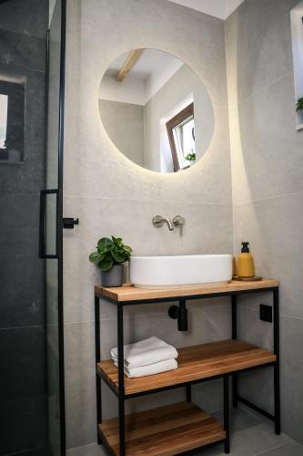 a bathroom with a sink and a mirror at Domki wakacyjne 4 YOU in Ustka