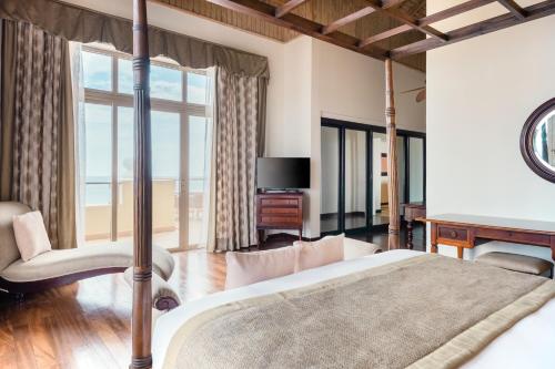 a bedroom with a bed with a television and a desk at Iberostar Waves Rose Hall Beach - All Inclusive in Montego Bay