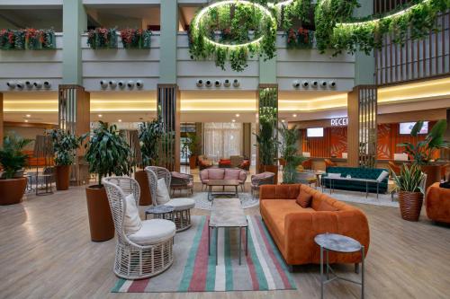 a lobby with a couch and chairs and plants at Megasaray Resort Side in Side