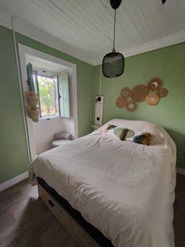 a bedroom with a large bed with green walls at Como EM Casa in Alburitel