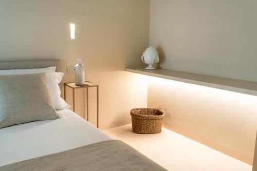 a bedroom with a white bed and a basket at NEW OPENING - Palazzo Gasparino Suites in Monopoli