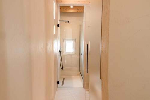 a hallway with white walls and a door with a window at NEW OPENING - Palazzo Gasparino Suites in Monopoli