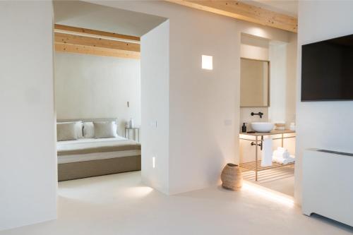 a white room with a bed and a sink at NEW OPENING - Palazzo Gasparino Suites in Monopoli